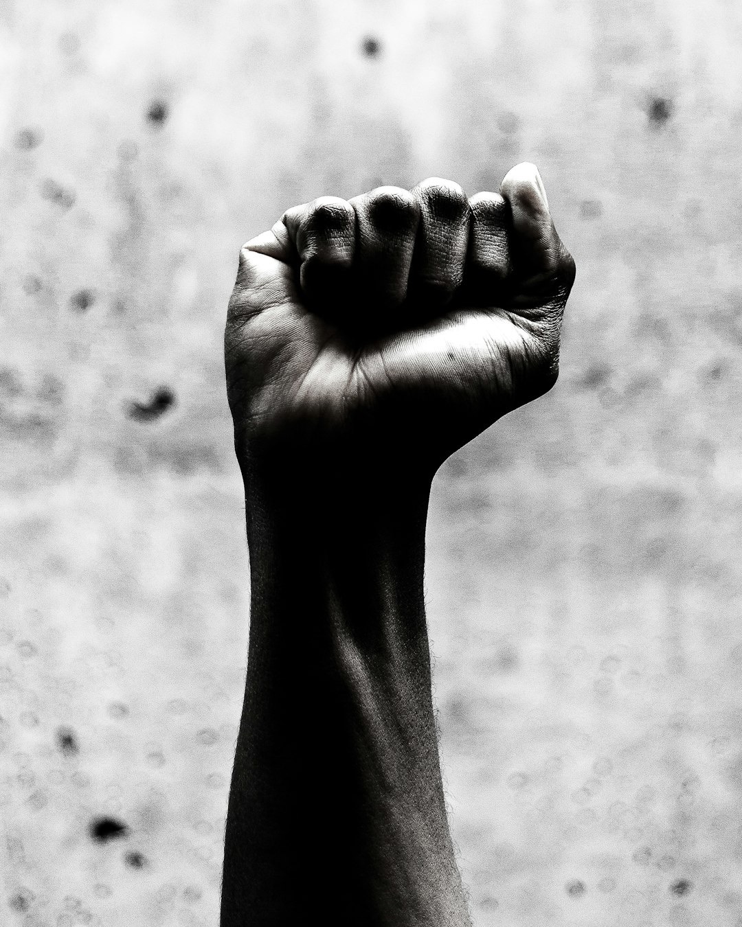 Clenched fist and forearm raised in determination.